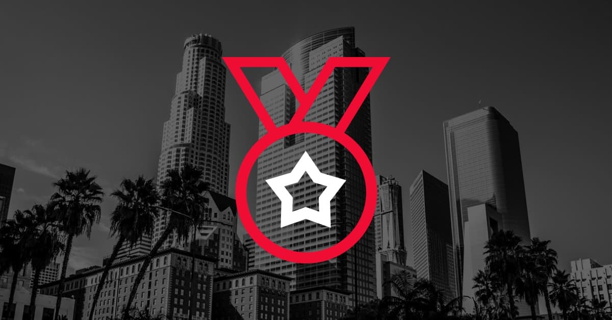 A skyline of tall buildings in black and white, with a red medal icon featuring a white star in the center.